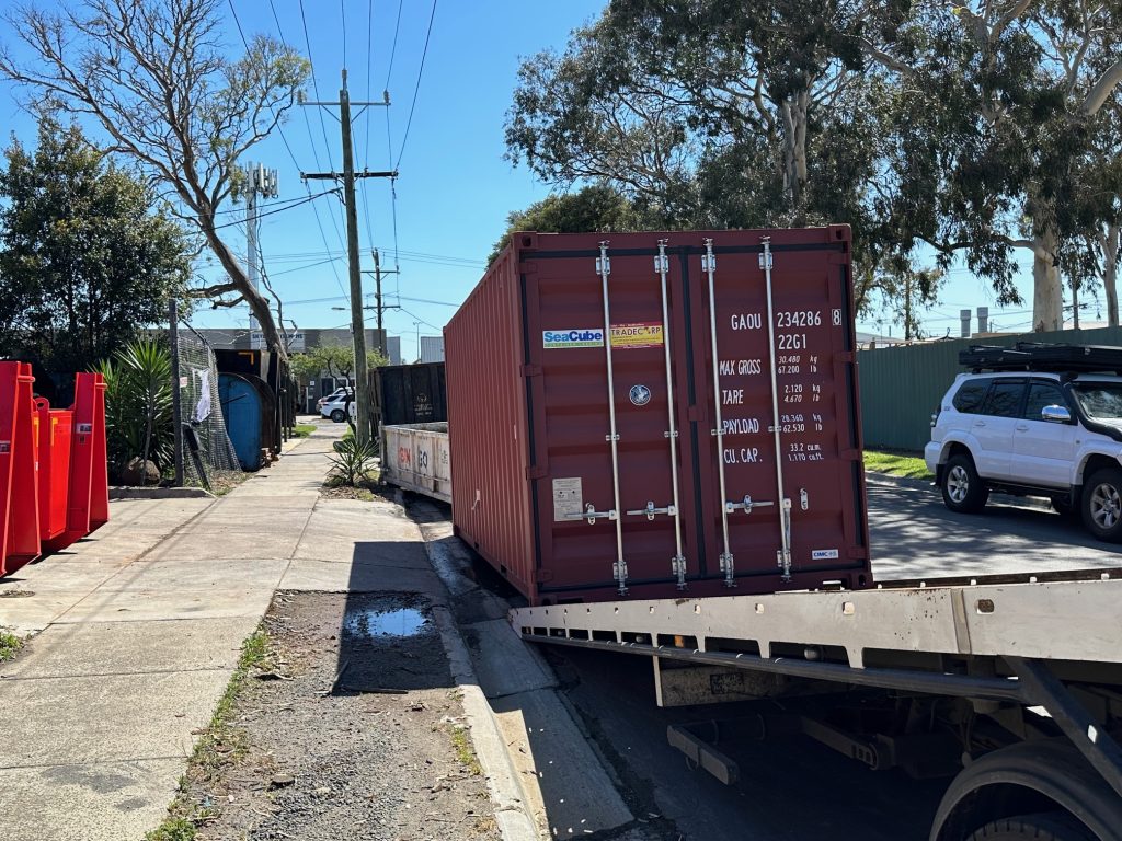 shipping container delivery with tilt tray