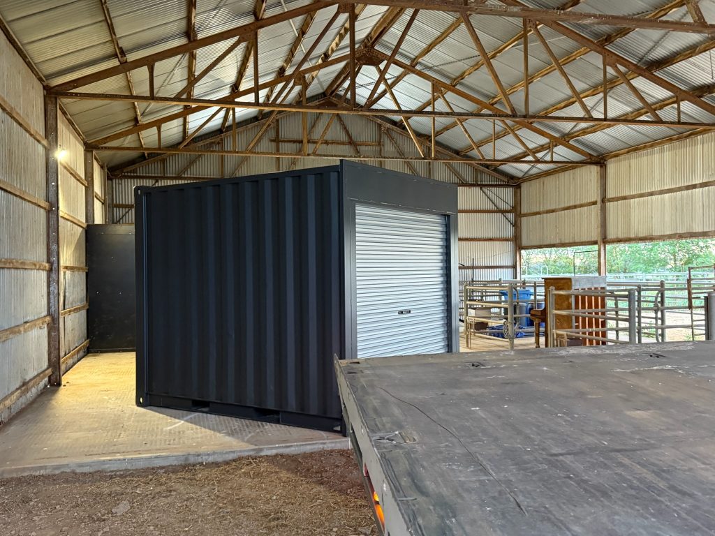 Shipping container with roller door placed inside a farm shed near Shepparton